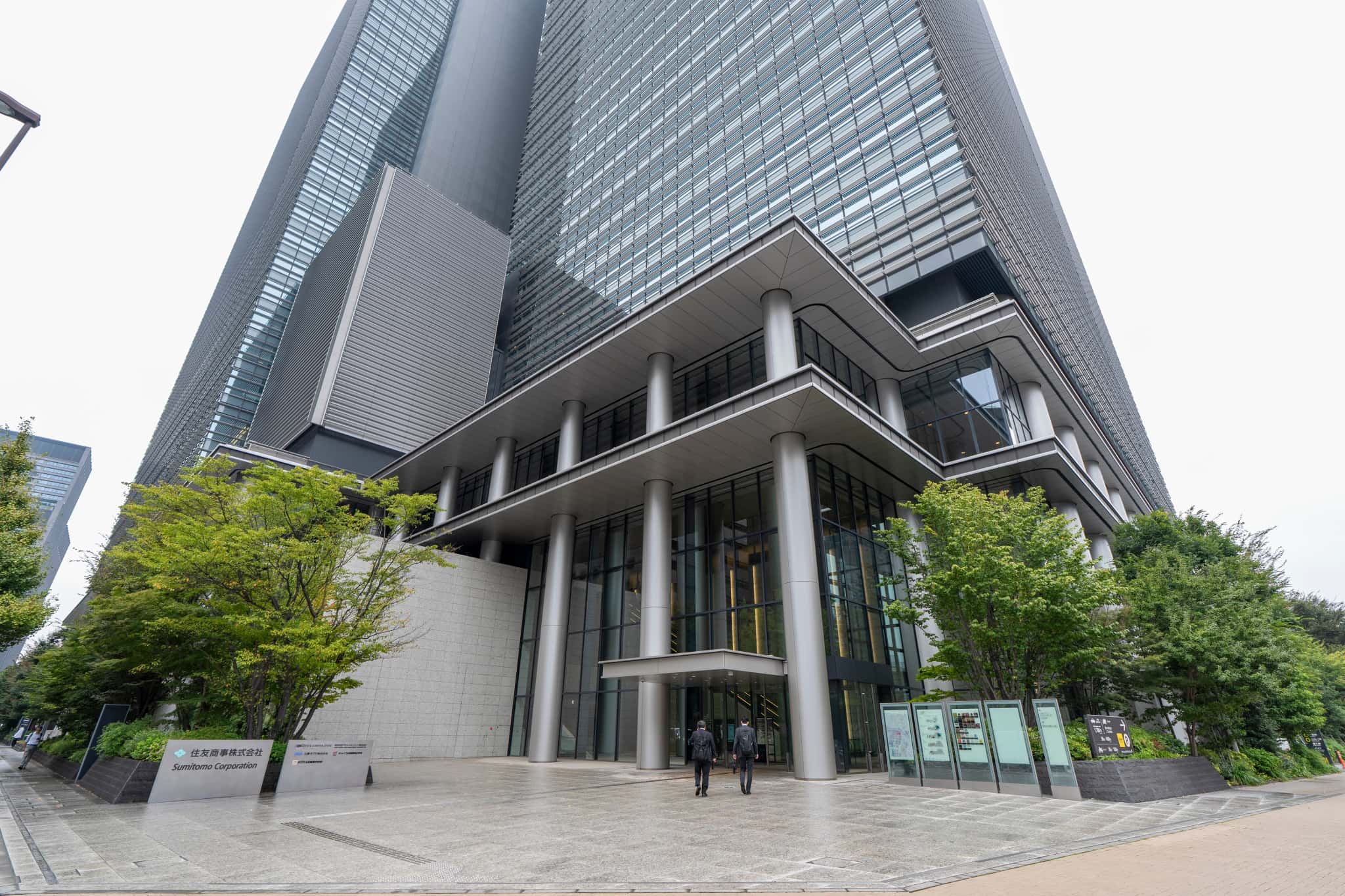 大手町プレイス ホール&カンファレンス会場内の大きなセミナールーム。木目調の壁面と格子状の音響天井パネル、黒いスタッキングチェアが並べられている。